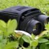 Compact binoculars with carrying case in a natural setting.