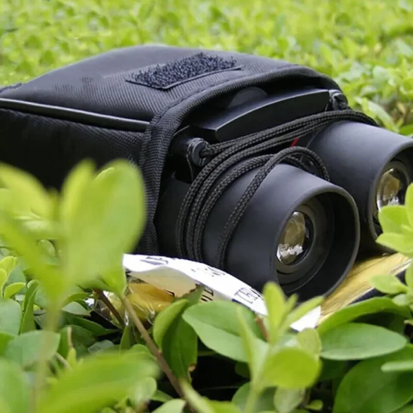 Compact binoculars with carrying case in a natural setting.